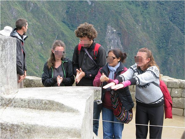 Tourists at the Hitching Stone in Machu Picchu