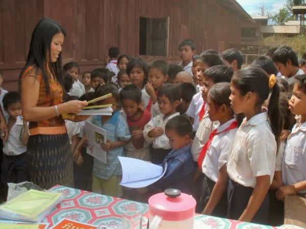 4m2 - Massimo’s wife Bangon handing over books in Lao language to the children of the local school.